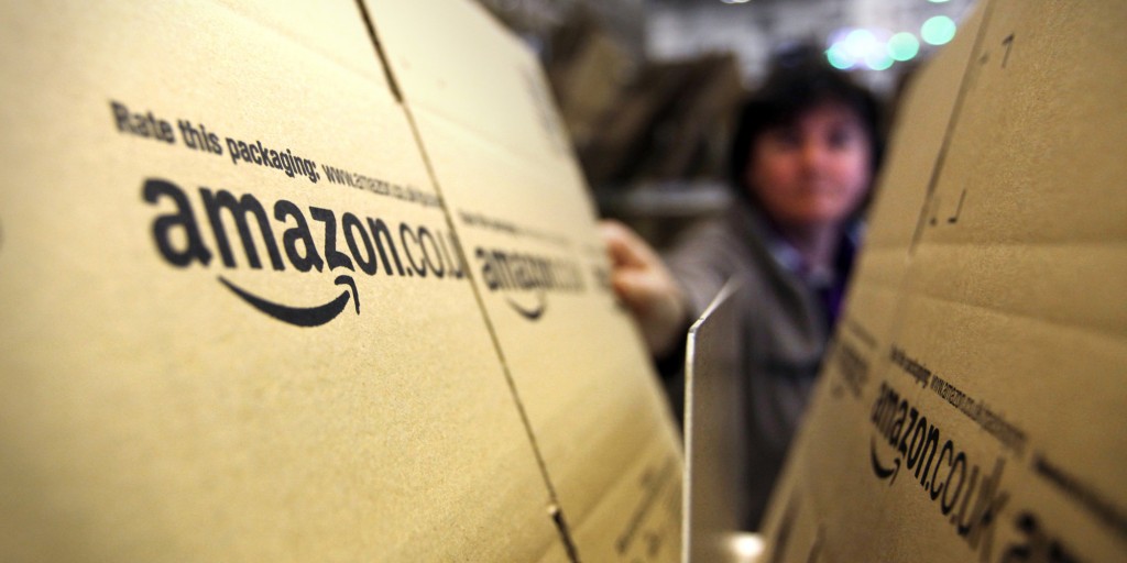 An employee selects a branded cardboard box at the Amazon.co.uk. Marston Gate 'Fulfillment Center,' the U.K. site of Amazon.com Inc., in Ridgmont, U.K., on Monday, Dec. 5, 2011. Amazon.com Inc.'s share of the tablet computer market will surge to 14 percent this quarter as consumer demand catapults the Kindle Fire to the No. 2 spot after Apple Inc.'s iPad, according to research firm IHS Inc. Photographer: Chris Ratcliffe/Bloomberg via Getty Images